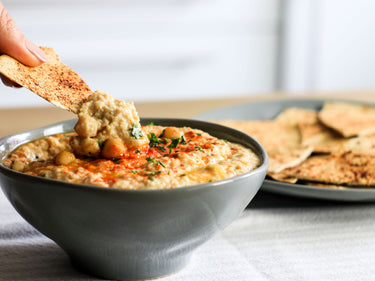 Low calorie Lo-Dough crackers dipping in homemade hummus